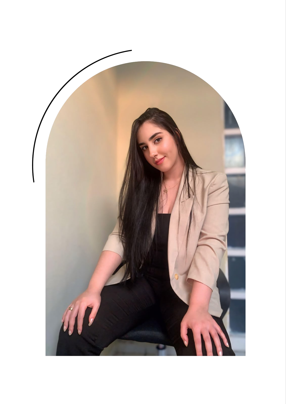 Ana Lívia sentada em retrato profissional com blazer claro