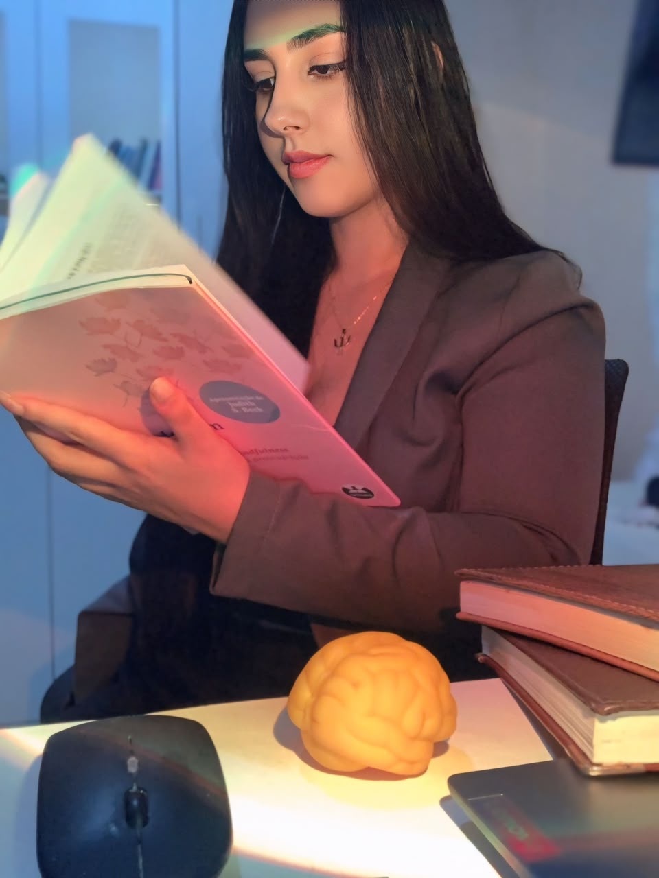 Ana Lívia lendo um livro em seu espaço de estudos